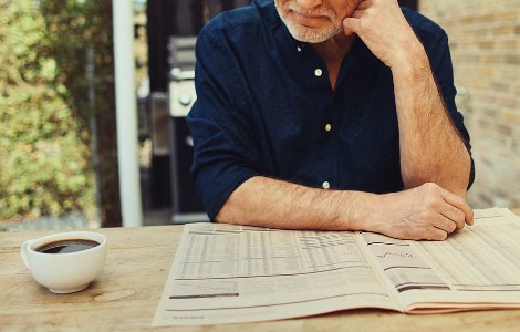 A man reading the paper with a cup of coffee