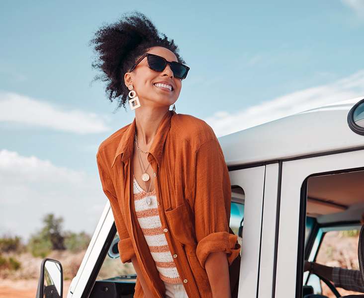woman hanging out of truck window enjoying scenery