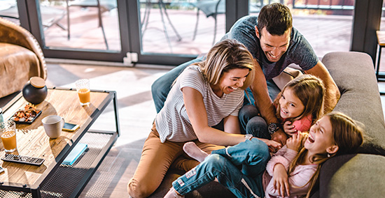 Family laughing on a couch.